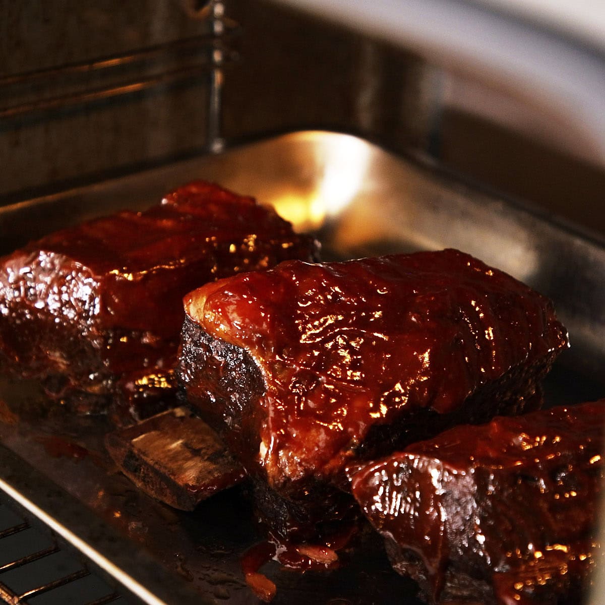 Roasting short ribs glazed with sauce.