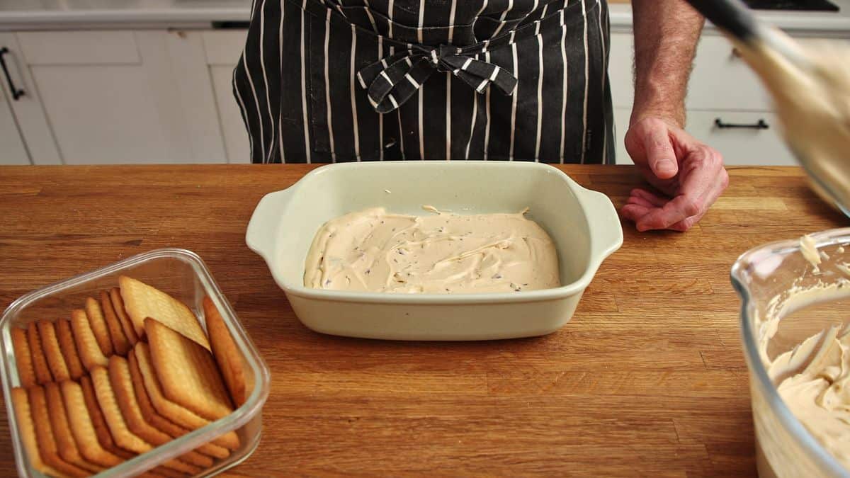 First layer of caramel mousse spread in ceramic rectangular dish.