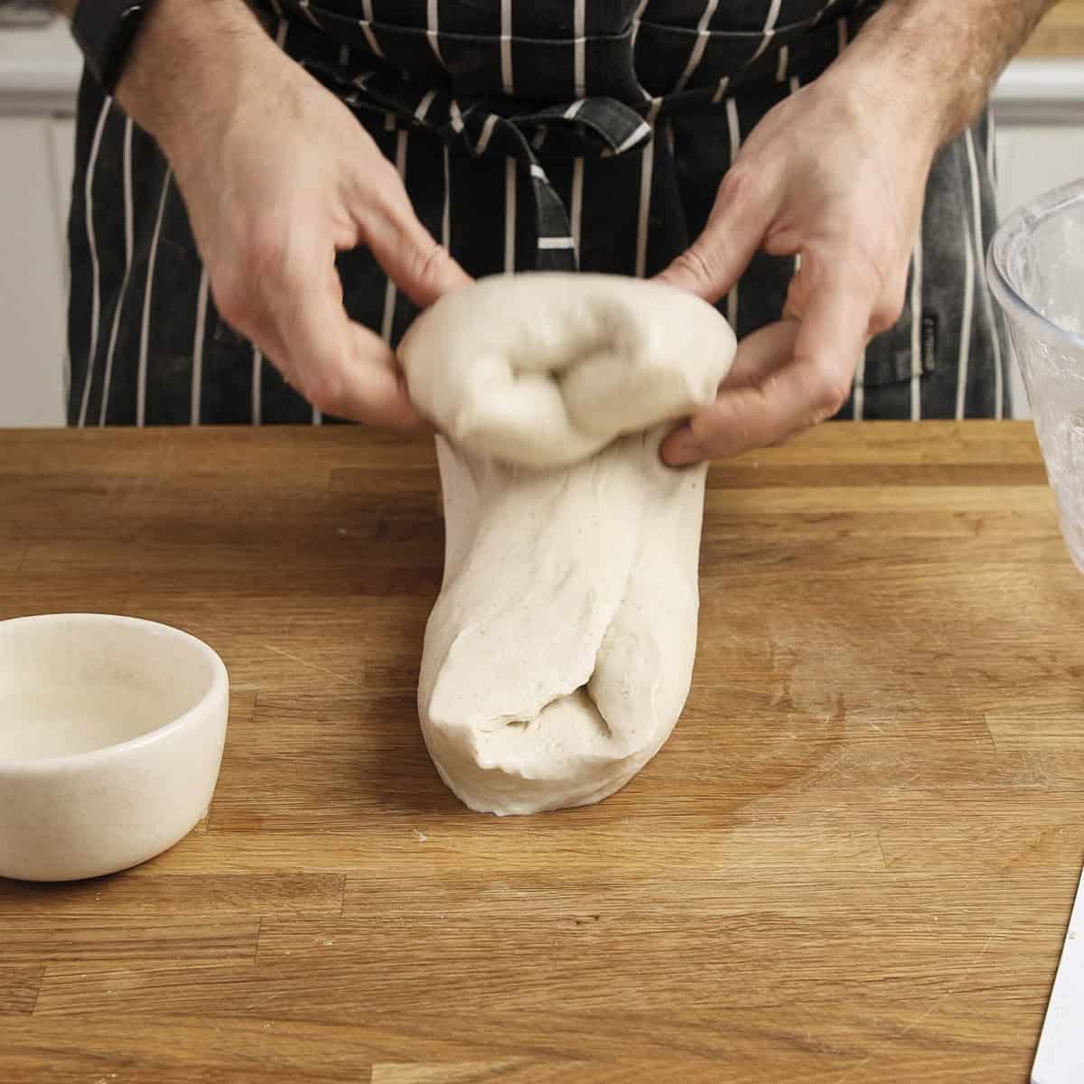 Performing a slap and fold on dough.