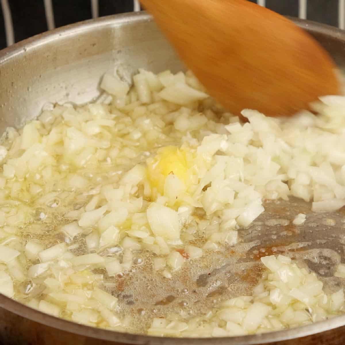 Frying chopped onions in ghee.