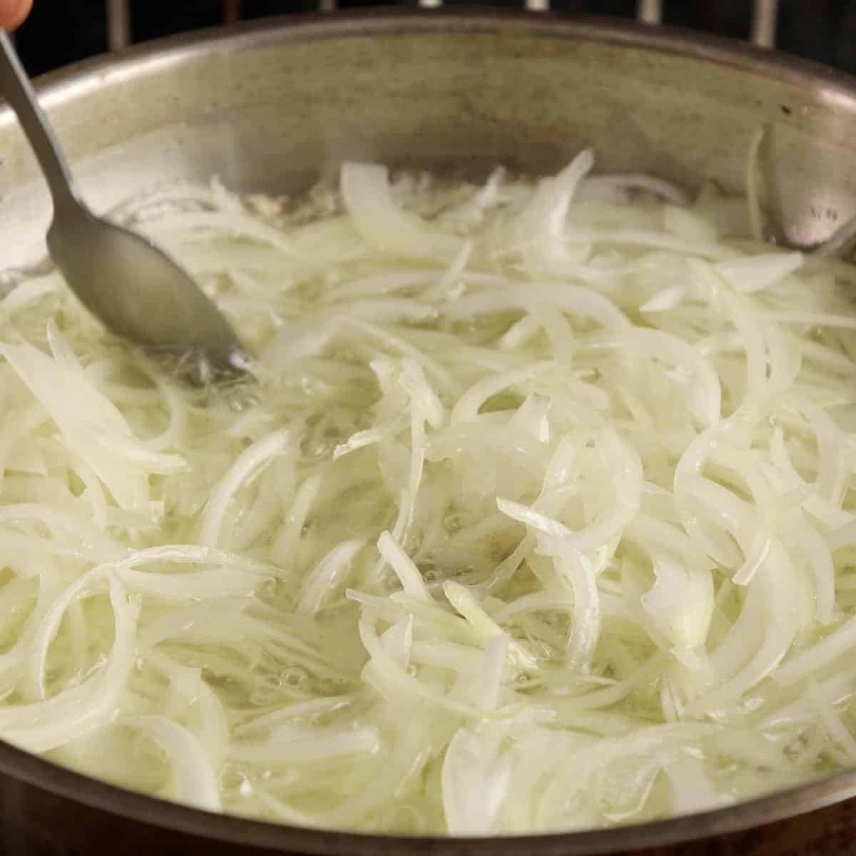 Sliced onions frying in oil.