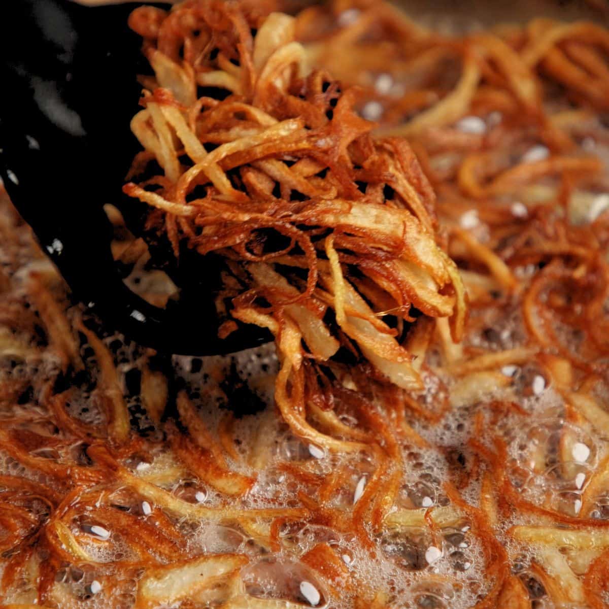 Golden brown onions frying in oil.