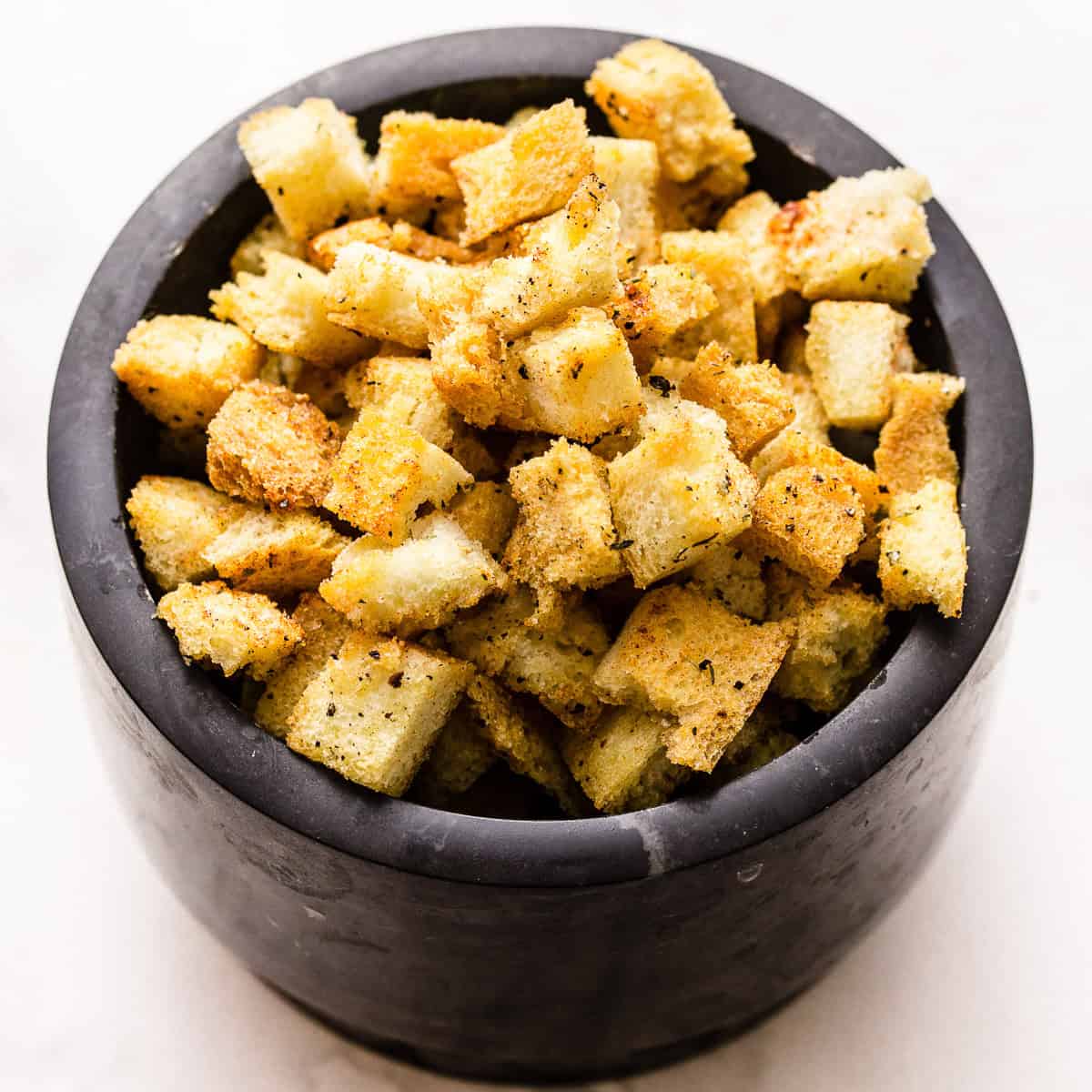 Garlic and herb brioche croutons in a bowl.