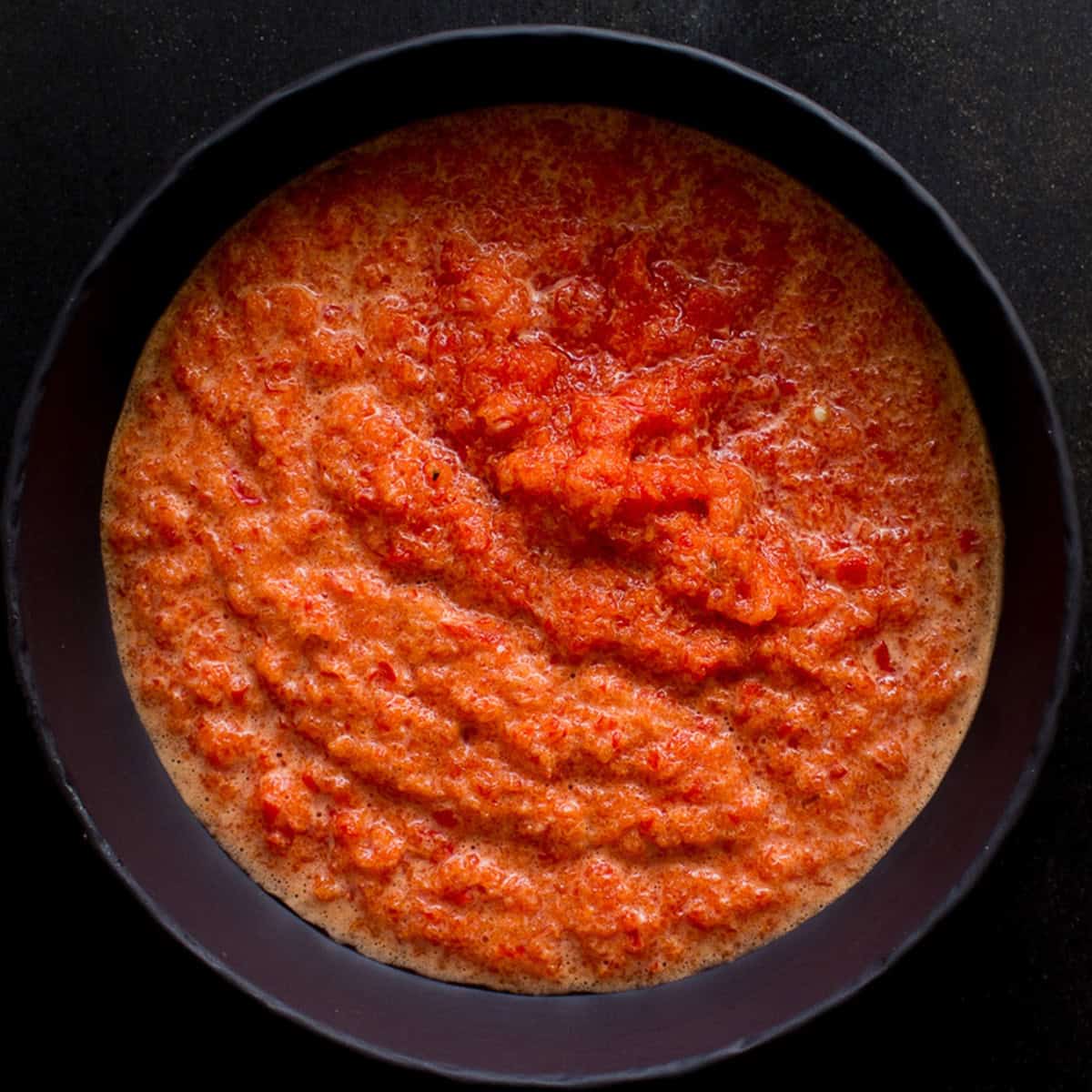 Garlic and pepper puree in a black bowl.