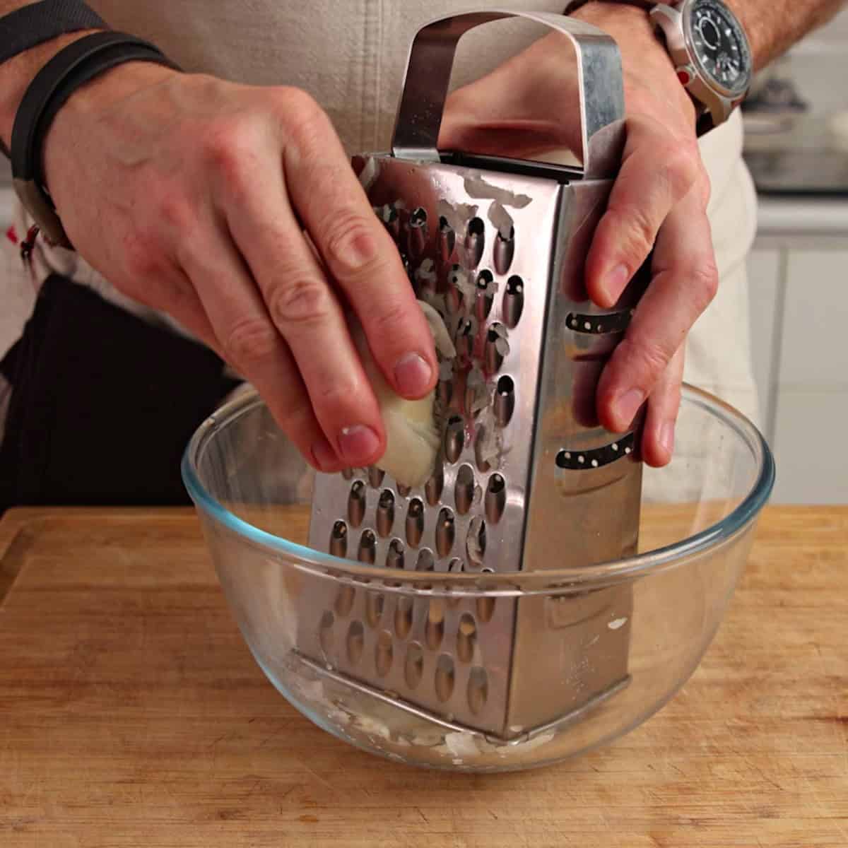 Grating onion on a box grater.