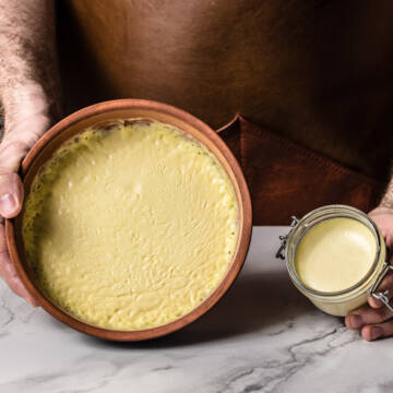 clotted cream in ceramic dish and glass jar on marble background