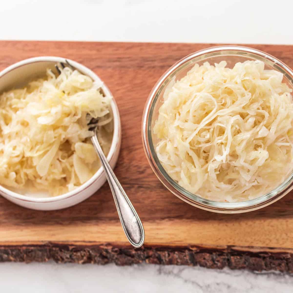 homemade sauerkraut in glass jars on wooden board