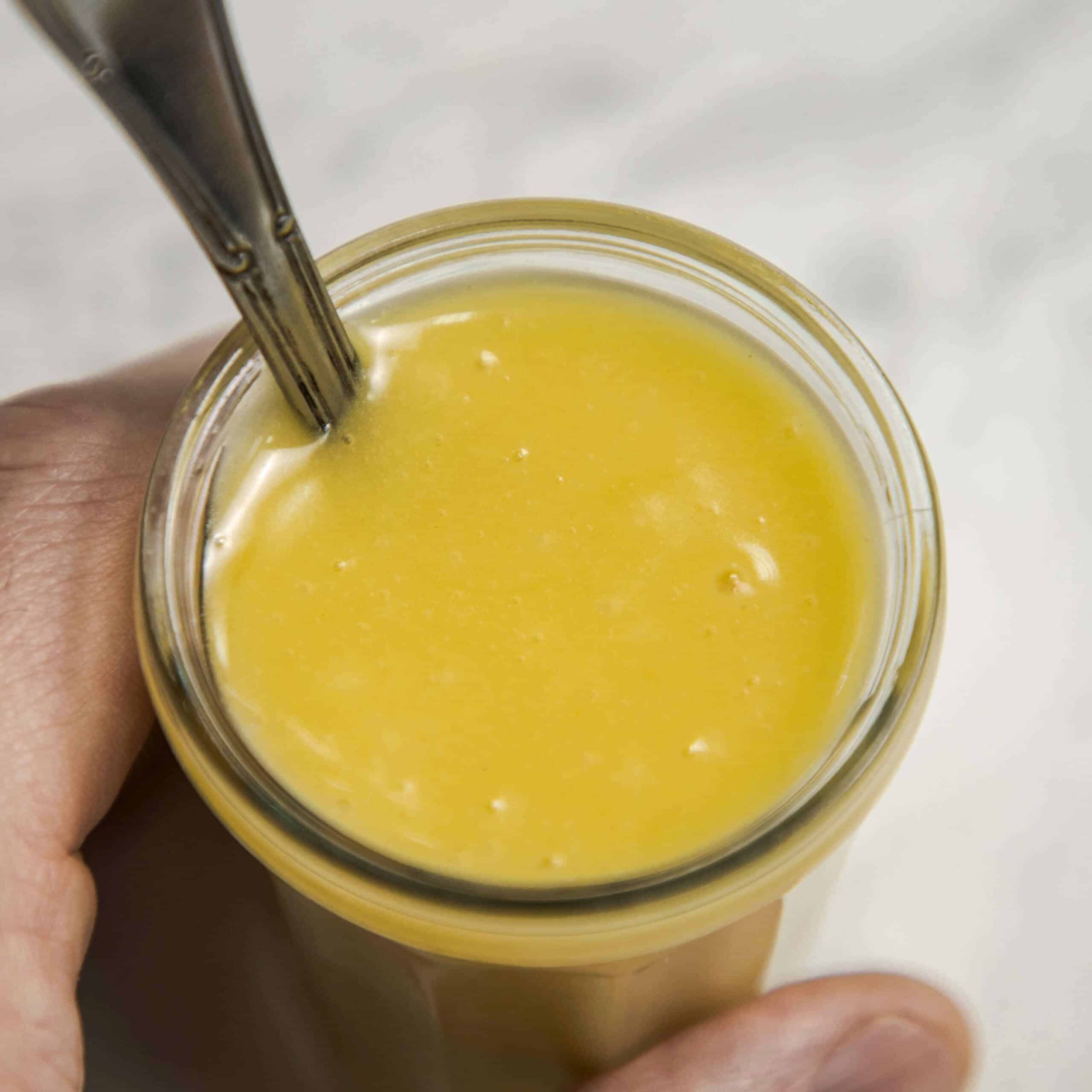 Honey mustard dressing in a glass jar.