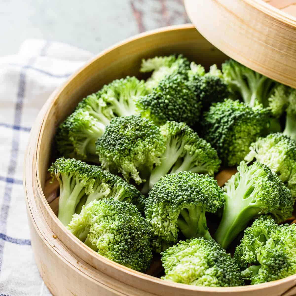 raw broccoli florets in a bamboo steamer basket