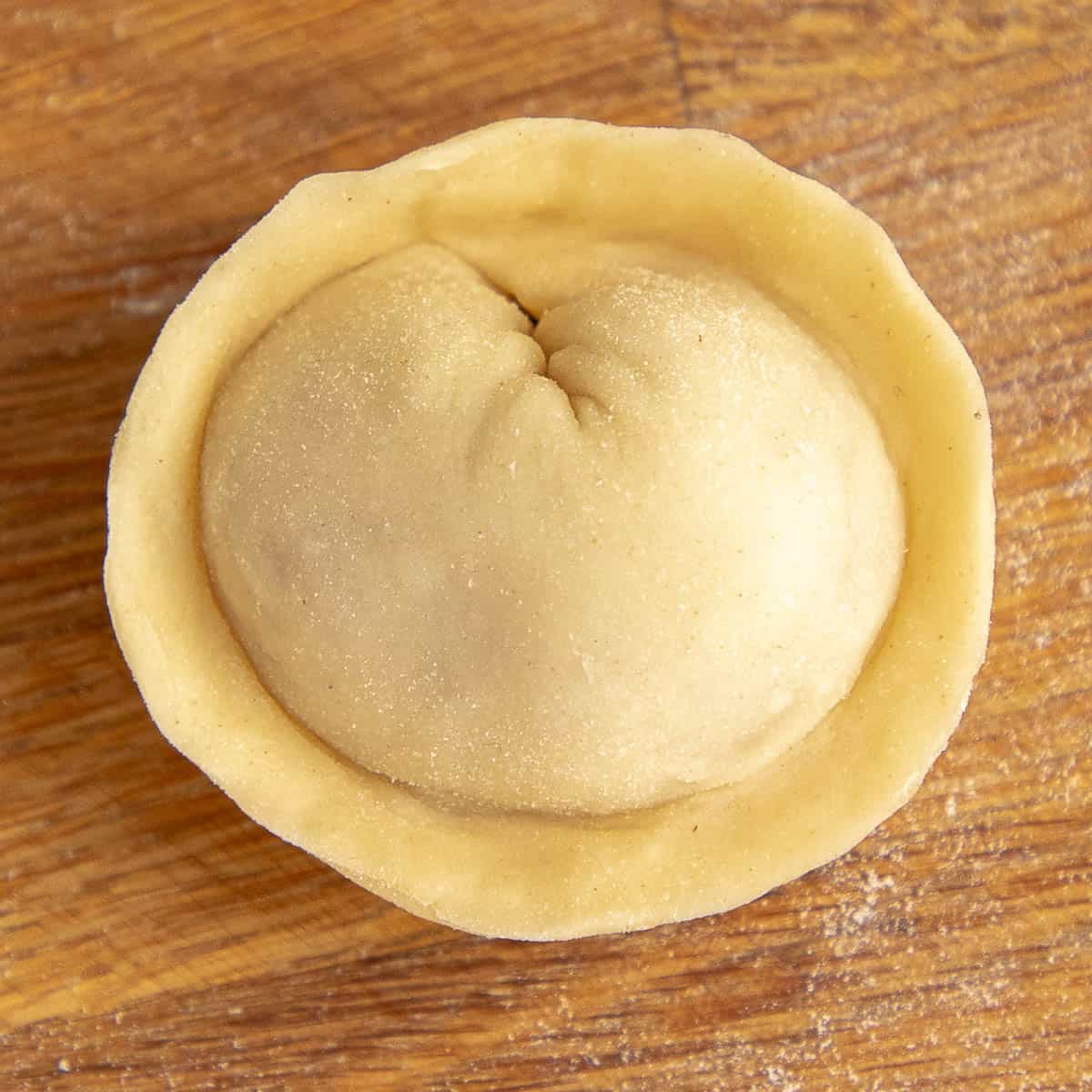 Shaped pelmeni on wooden board.