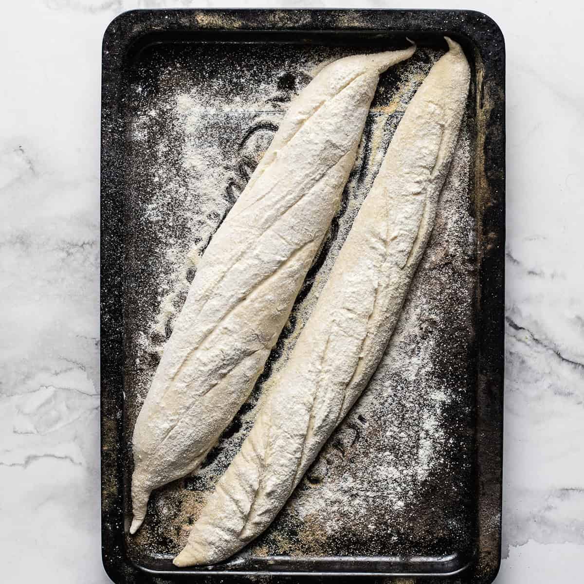 Scored breads on a baking sheet ready to be baked.