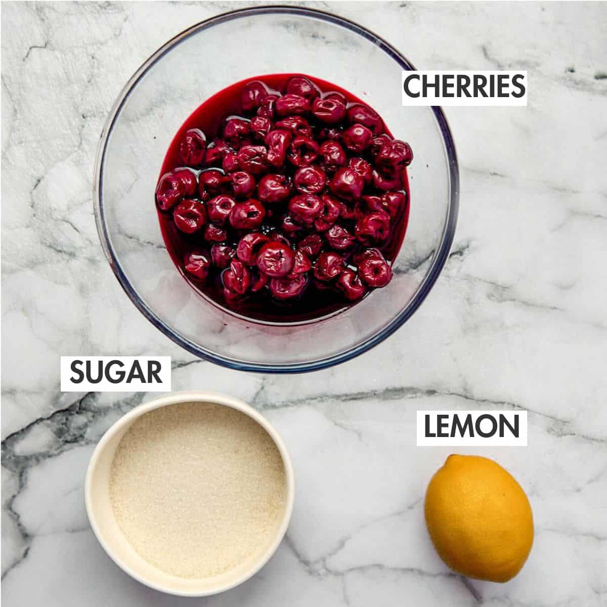 Ingredients for making cherry jam on a marble background.