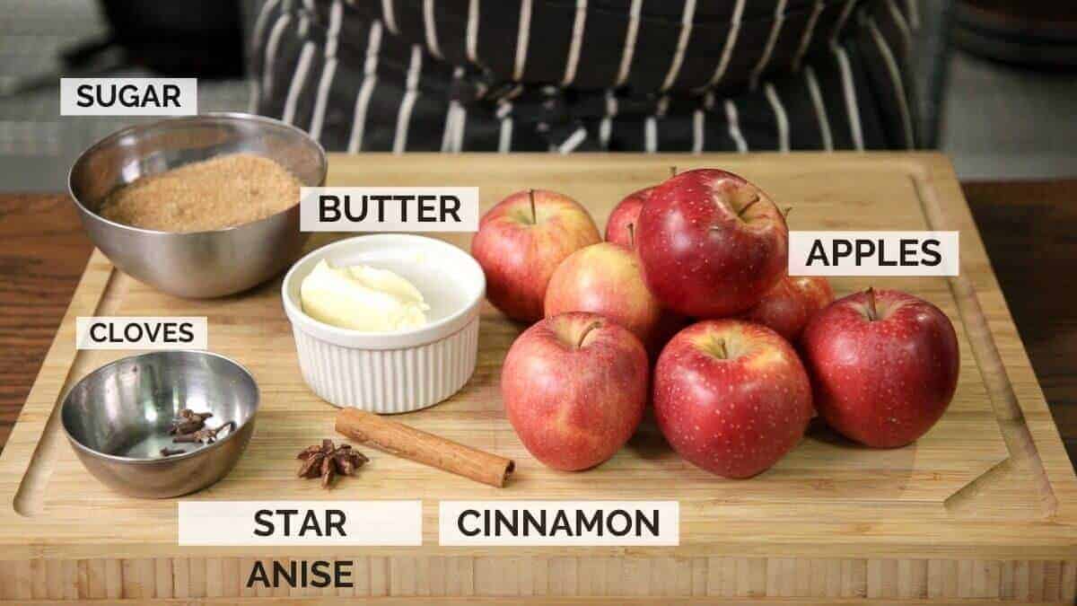 Ingredients for making apple piroshki filling on a dark wooden surface.