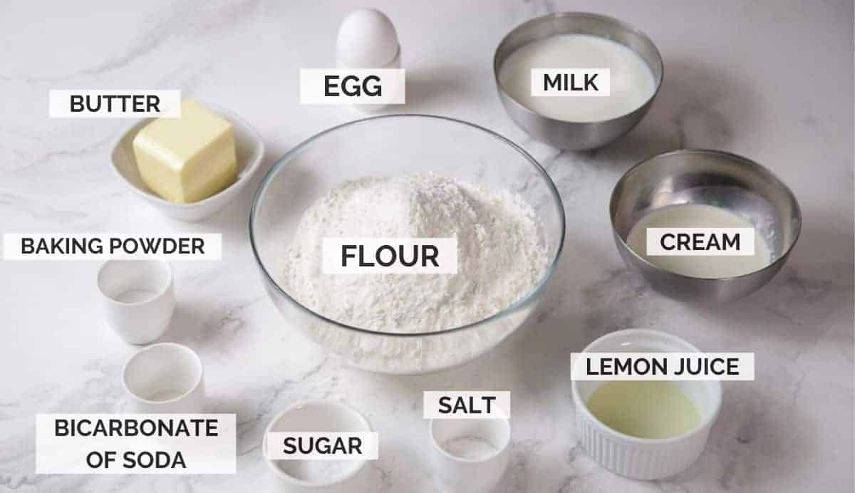 ingredients for making scones on a white marble background