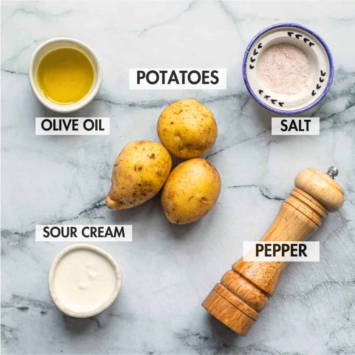 Ingredients for making crispy smashed potatoes on a marble background.
