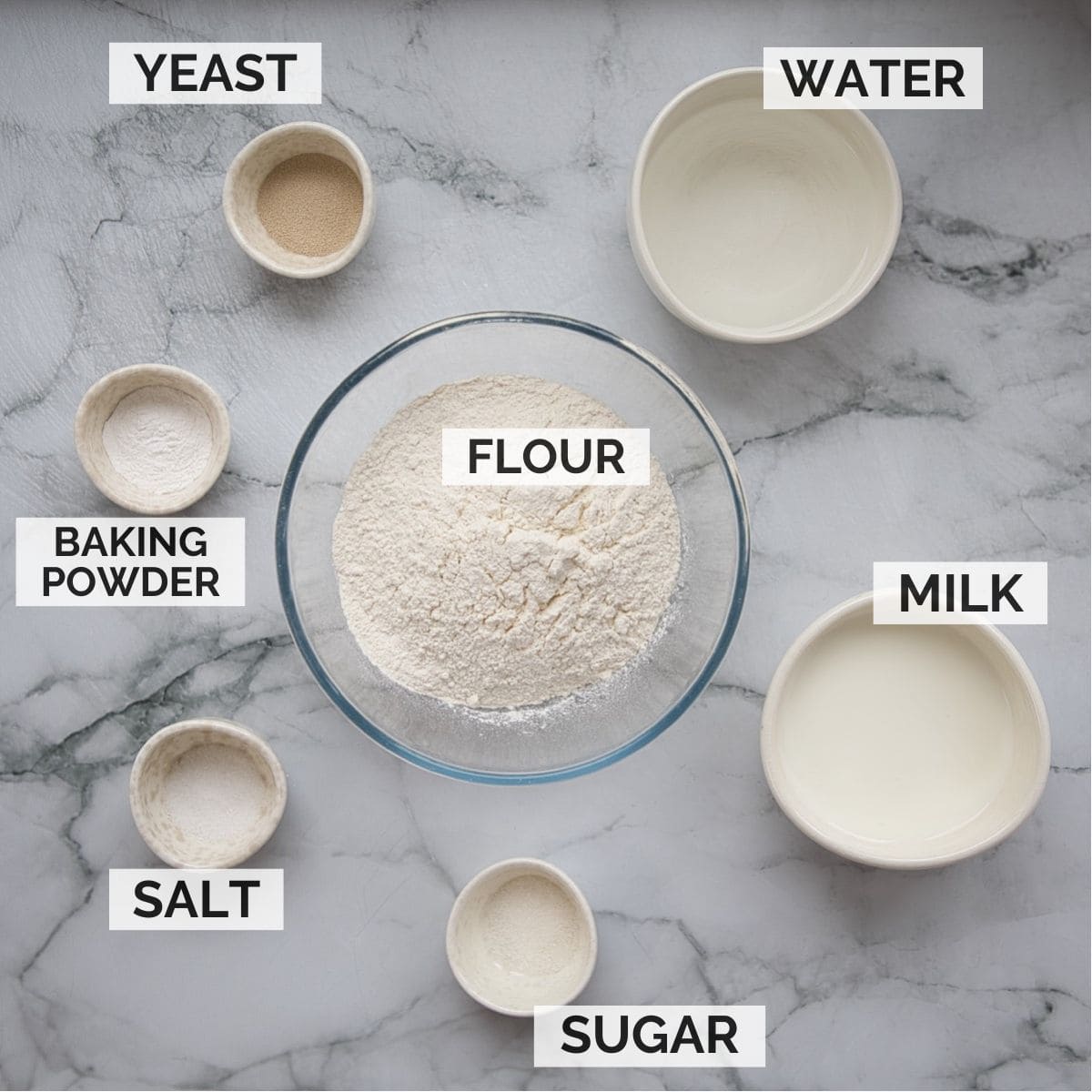 Ingredients for crumpets on a marble background.