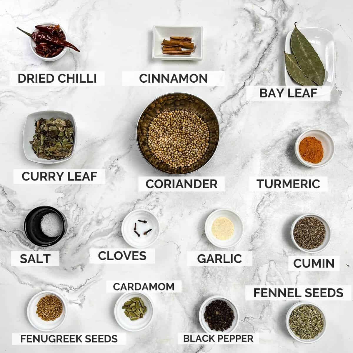 Ingredients for making curry powder on a marble background.