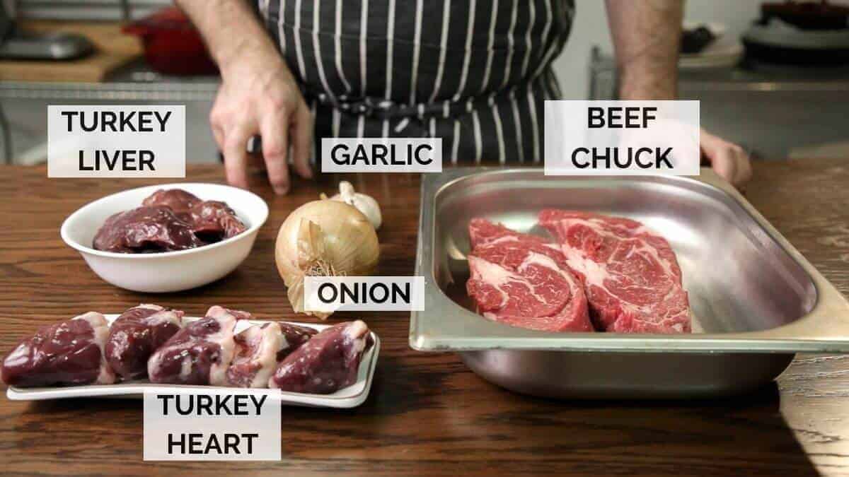 Ingredients for making meat piroshki filling on a dark wooden surface.