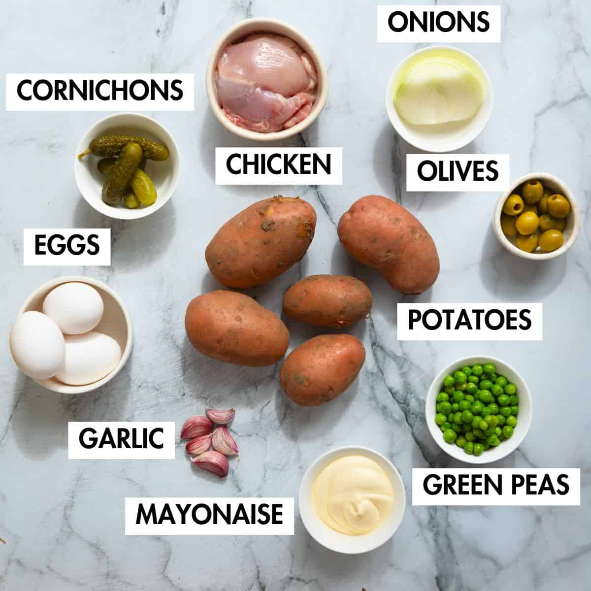 Ingredients for making Persian Olivieh salad on marble board.