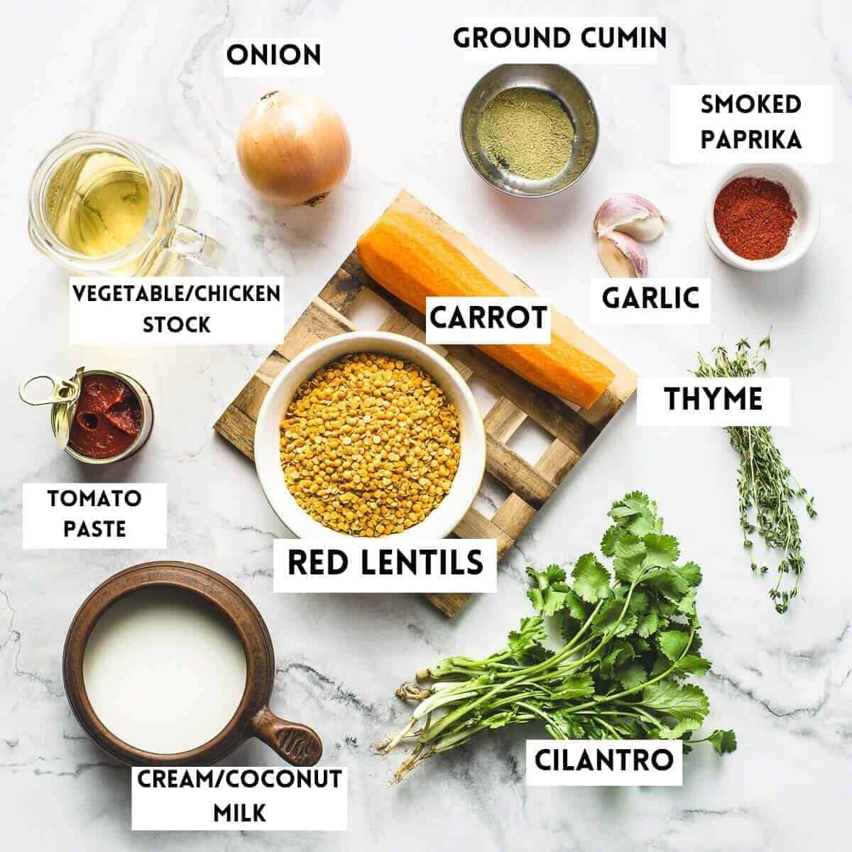 Picture of ingredients needed to cook red lentil soup. Carrot, onion, cilantro, thyme, cream, tomato paste, stock, garlic, spices