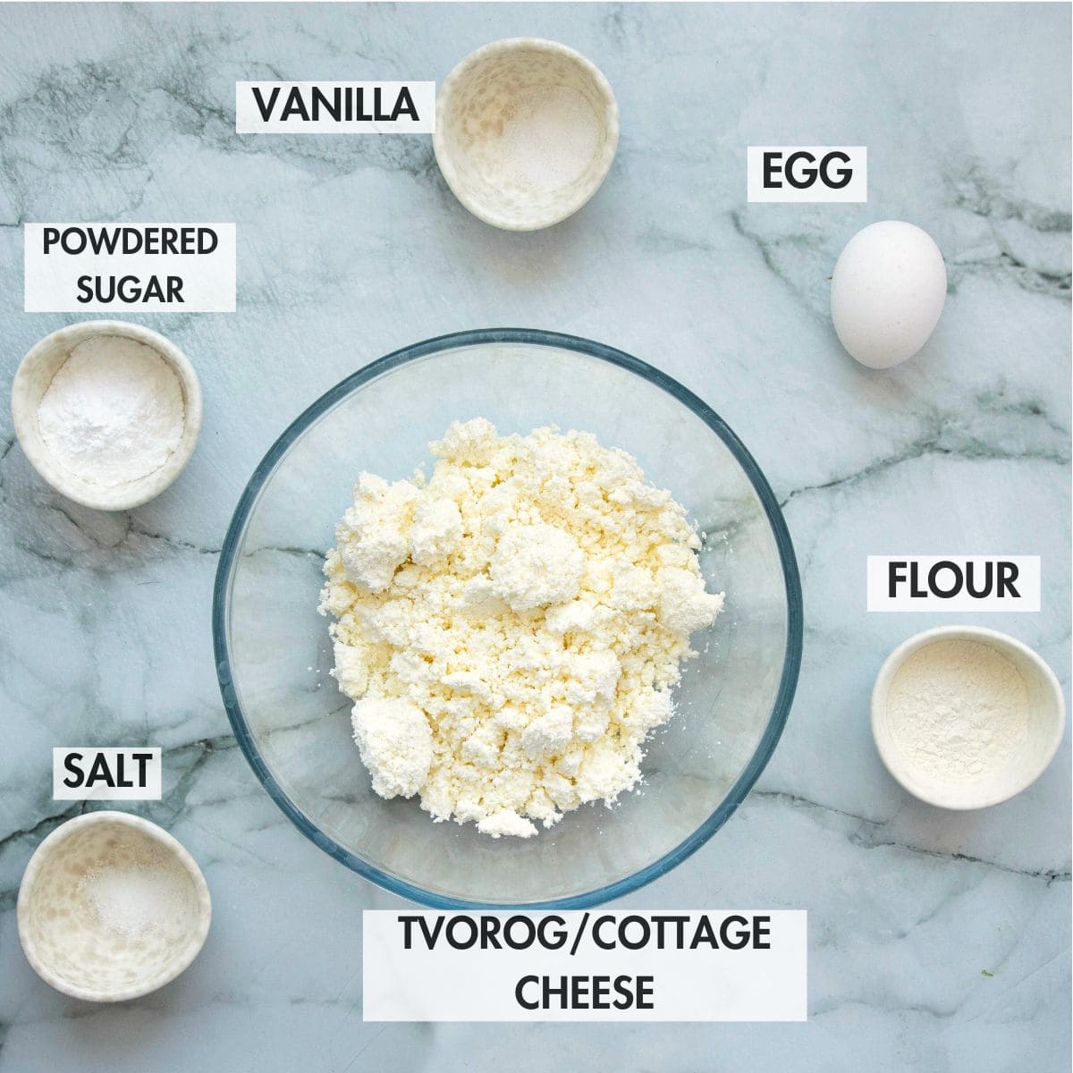 Ingredients for making syrniki on a marble board.
