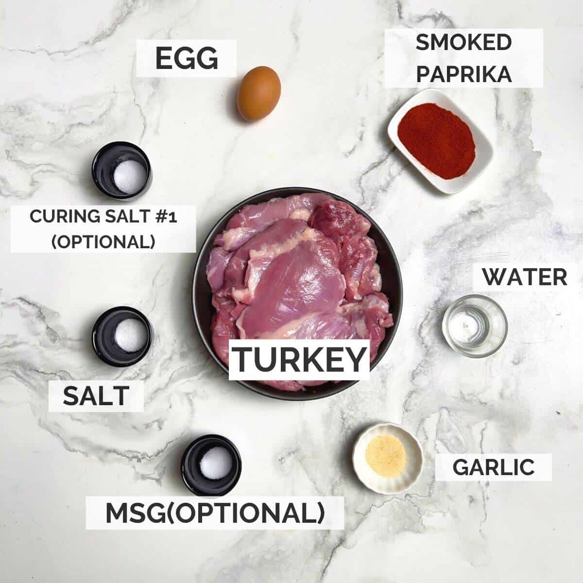 Ingredients for making turkey deli meat on a marbled background.