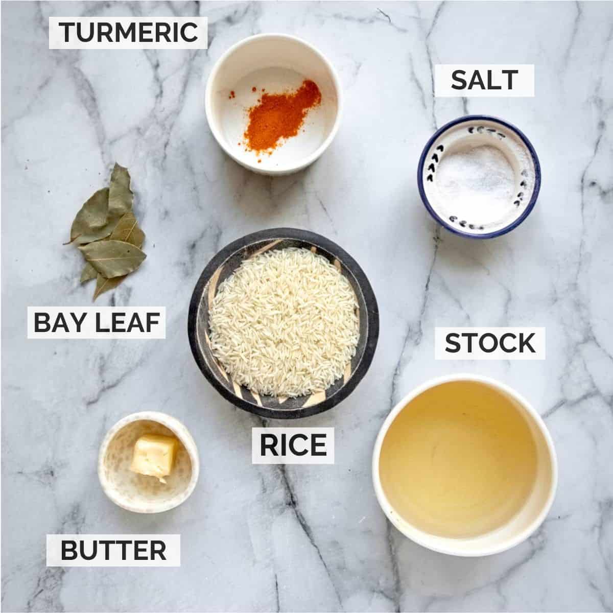 Ingredients for making yellow rice on a marbled board.