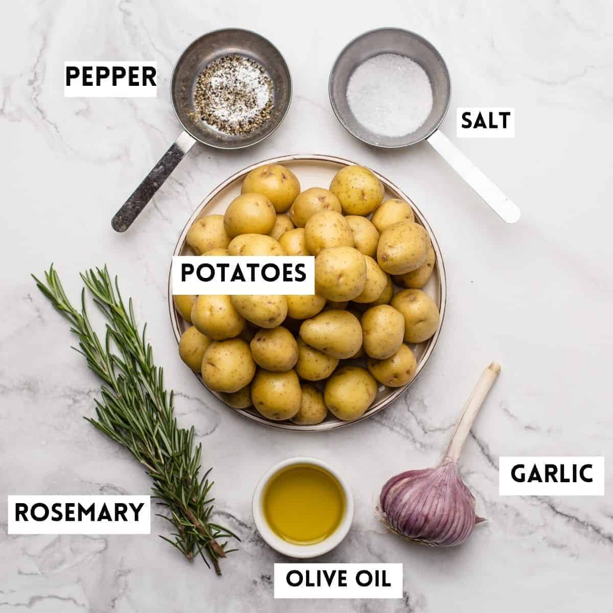 baby potatoes, rosemary, oil,garlic,salt,pepper on marble