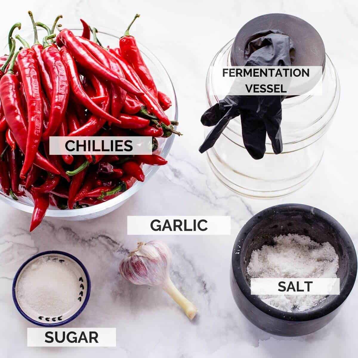 ingredients needed to make sriracha on marble background.