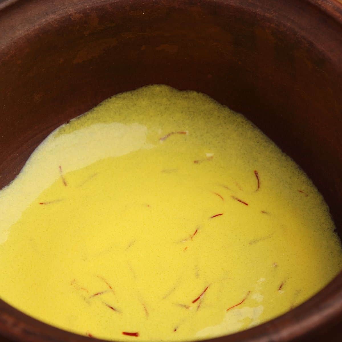 Saffron sauce in brown clay pot.