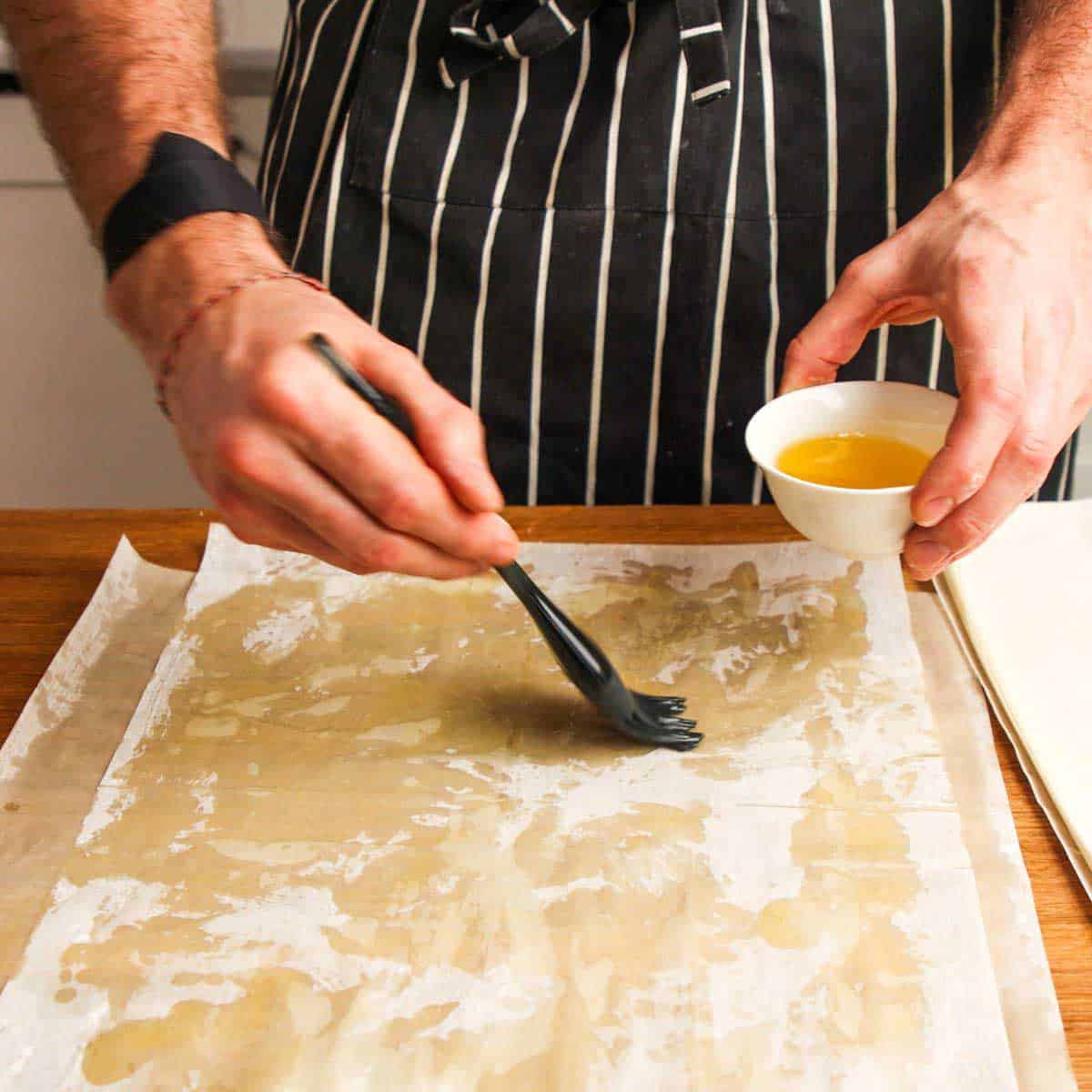 Brushing phyllo with butter.