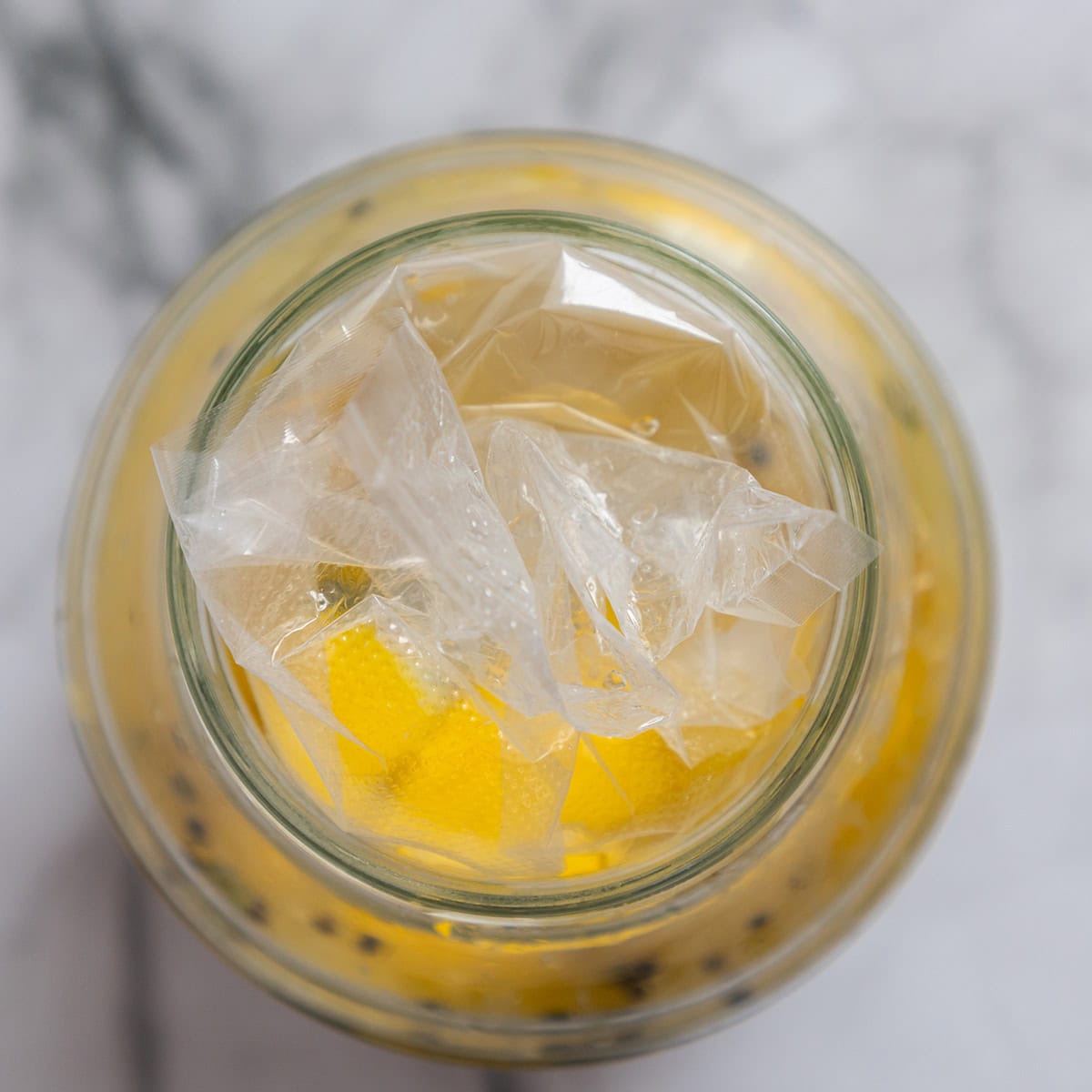 Lemons fermenting in a glass jar.
