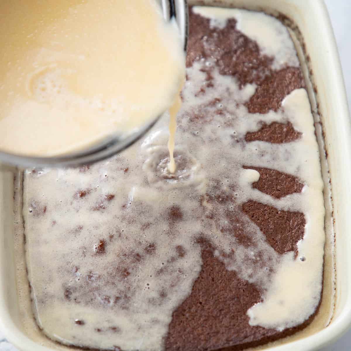 Pouring malva sauce over cake.