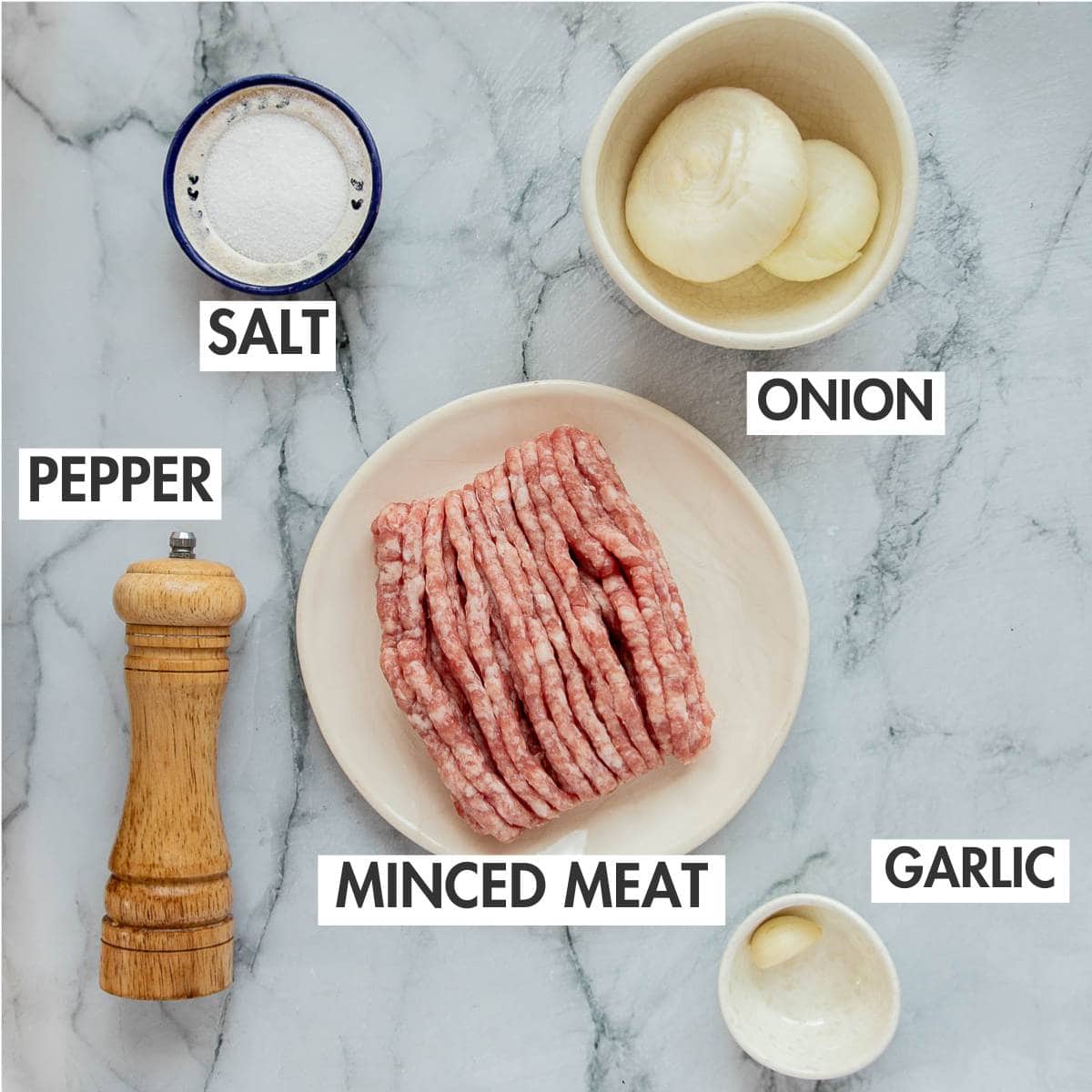 Meat pelmeni ingredients on a marble board.