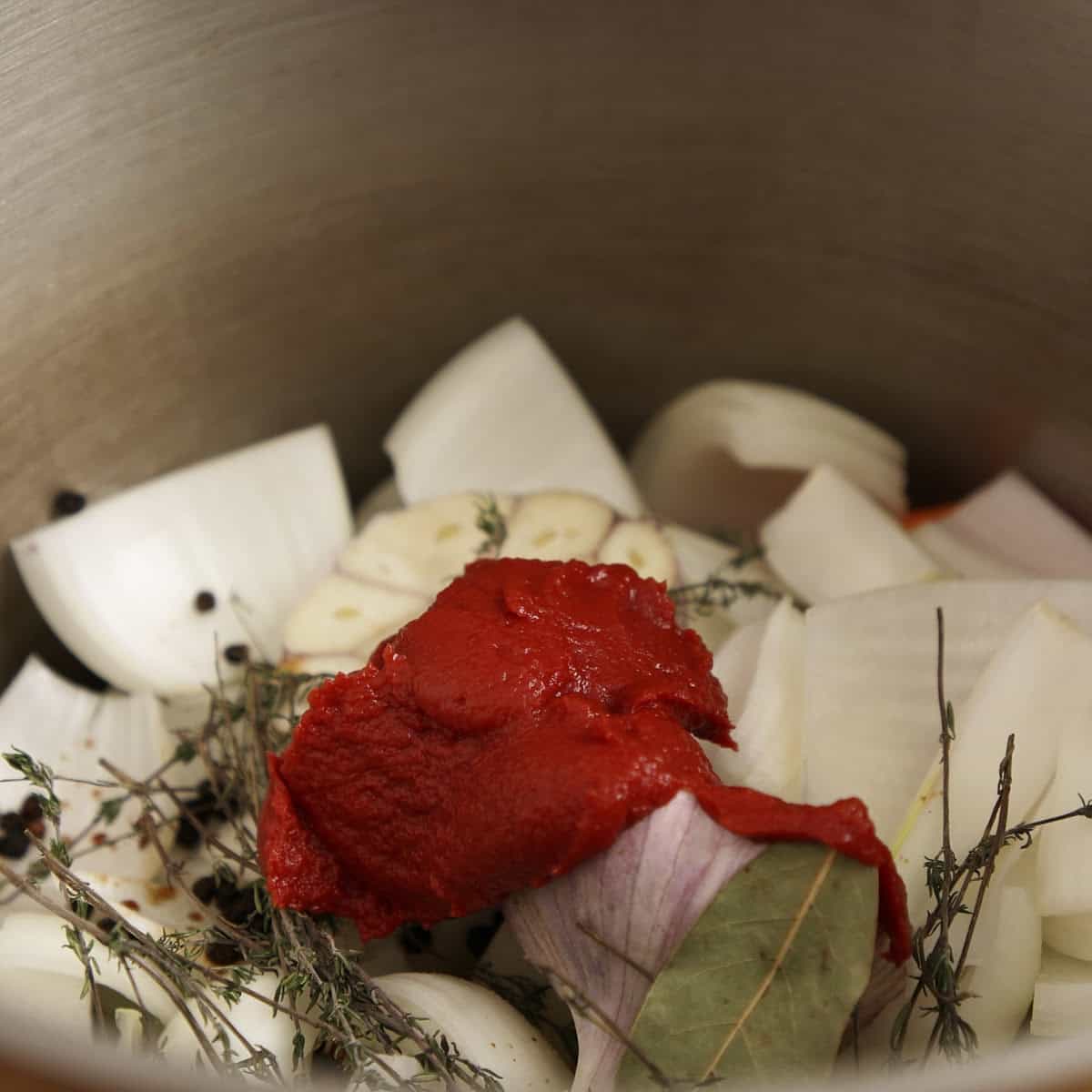 Mirepoix and tomato paste in a stock pot.