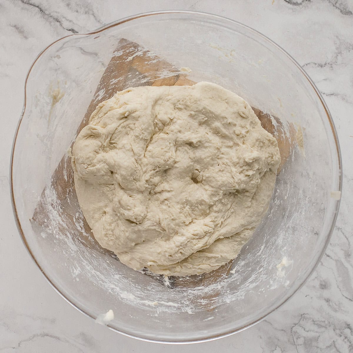 Autolyse sourdough baguette dough in a glass bowl.