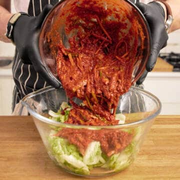 Mixing chilli and vegetable paste with salted cabbage.