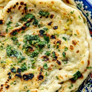 Naan breads with garlic butter and cilantro.