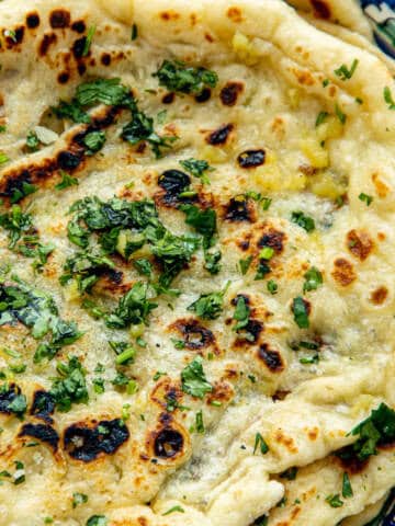 Naan breads with garlic butter and cilantro.
