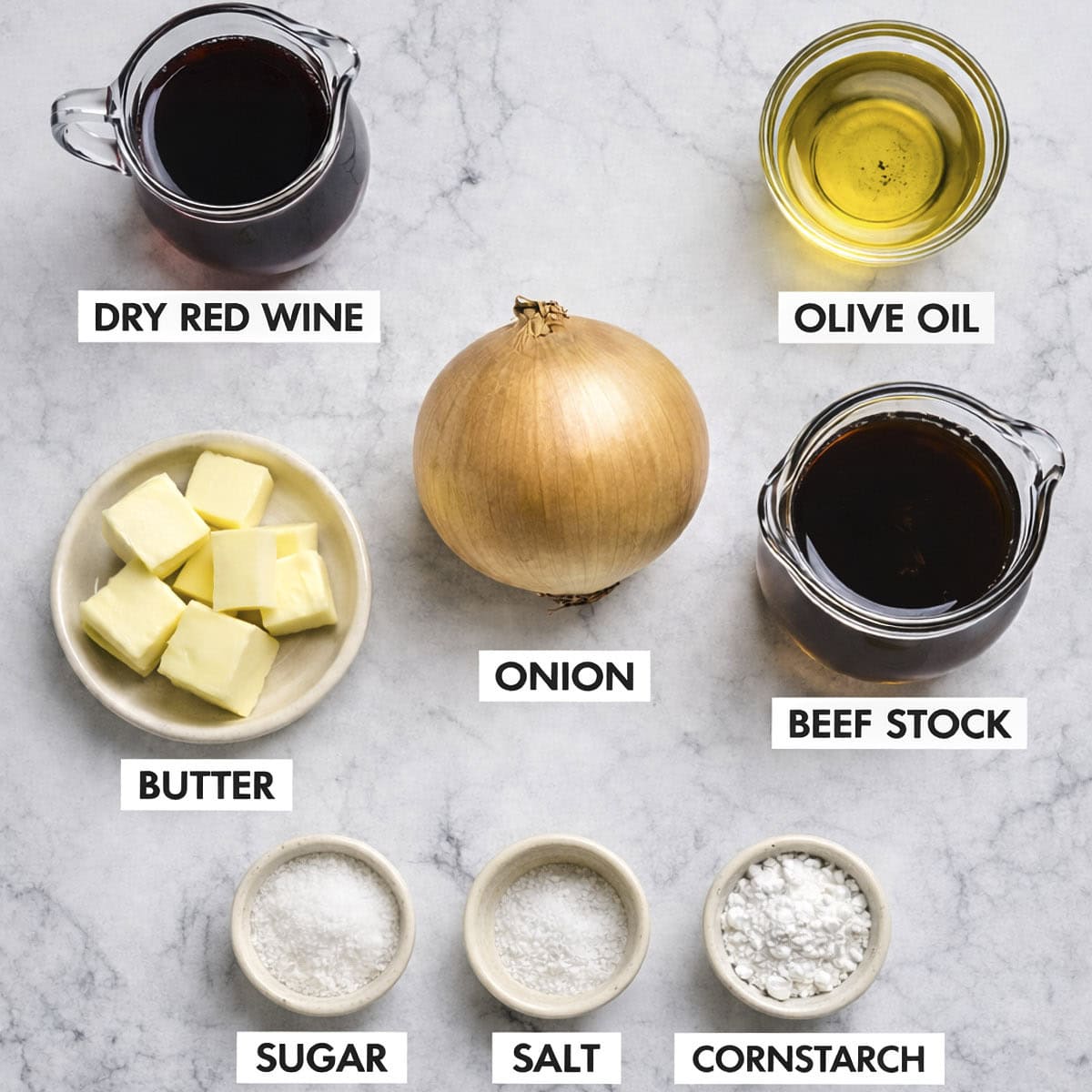 Ingredients for onion gravy on a marbled surface.