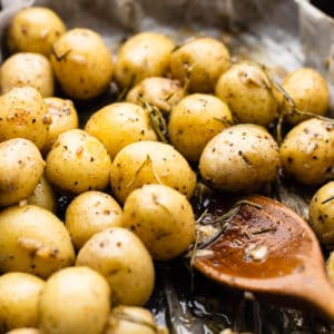 baked baby potatoes on oven tray with wooden spoon