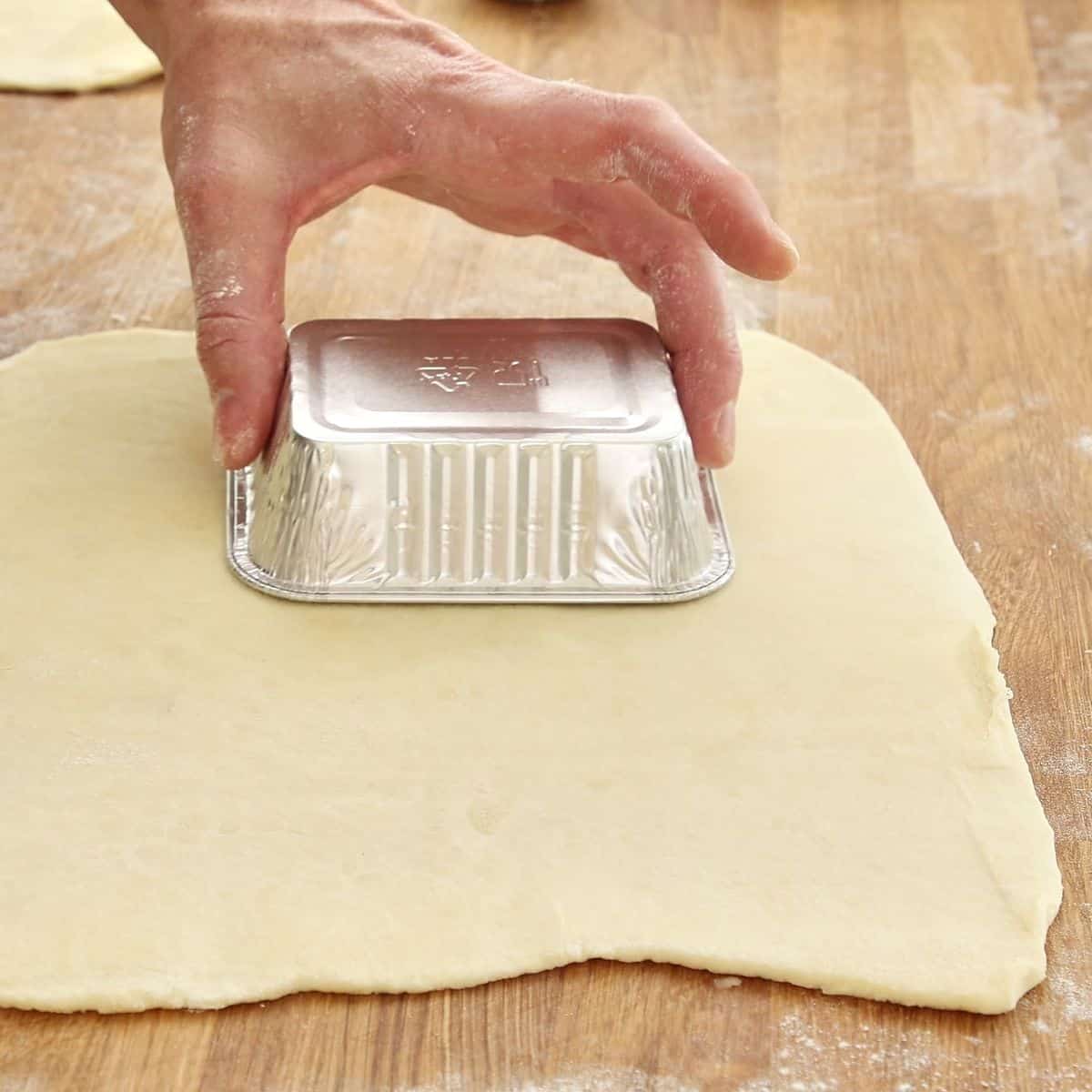 Pastry lids cut with slight overhang arranged on parchment paper ready for use