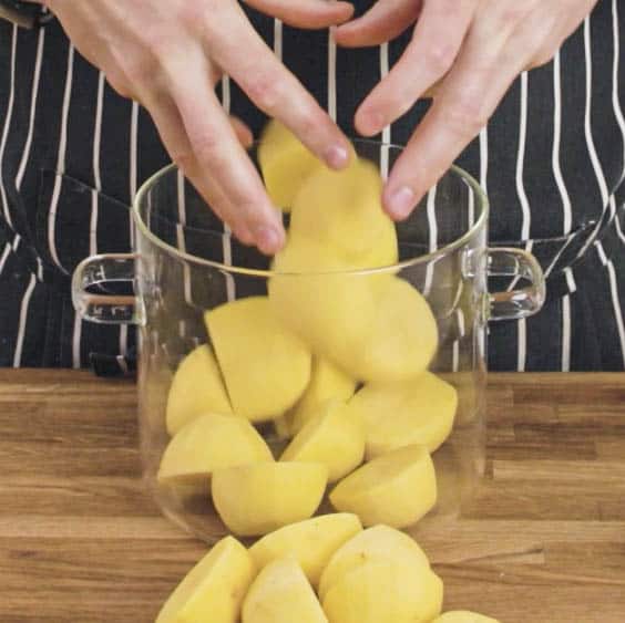 Washed, peeled and cut potatoes in a pot ready to boil.