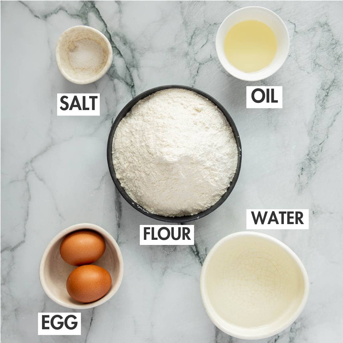Pelmeni dough ingredients on a marble board.
