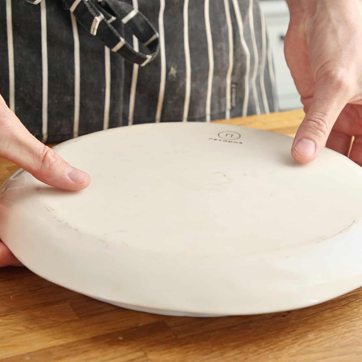 Upside down plate covering baked tart dish.