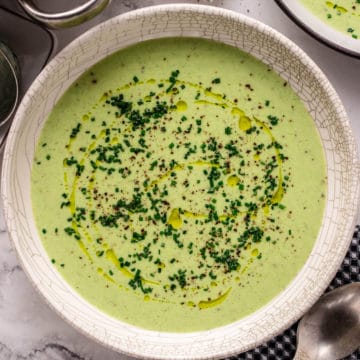 green potato leek soup in white bowl