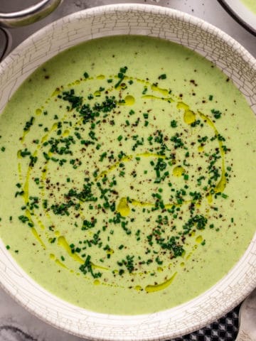 green potato leek soup in white bowl