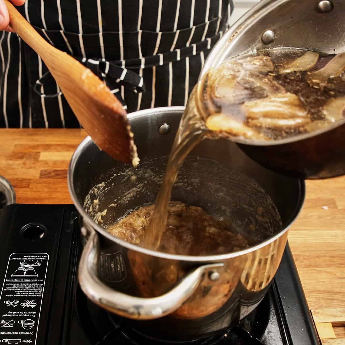 Biltong-infused stock poured into the roux base and stirred smooth.