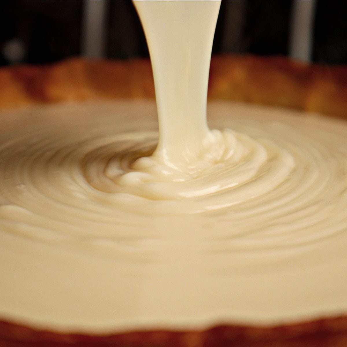 Pouring custard into pastry crust.