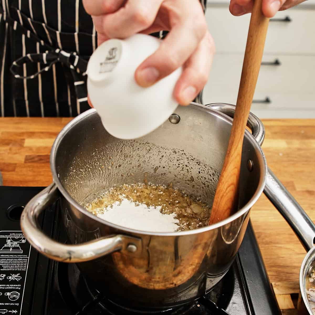 Flour sprinkled over the onion base to make the roux for biltong soup.